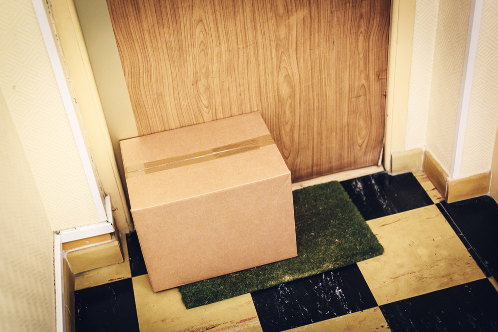 A packages sits outside of an apartment door
