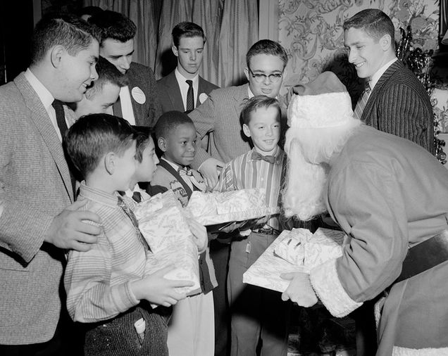 An acting Santa Claus gives gifts to children at Boston University Myles Standish Hall during a Christmas party for underprivileged children.