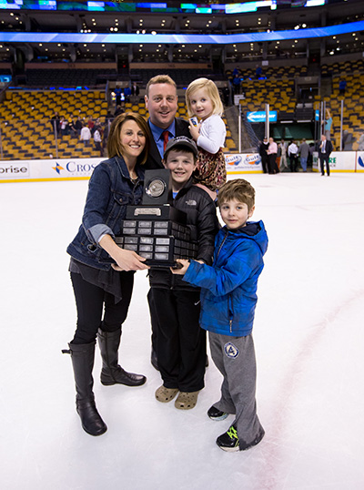 BU hockey head coach Albie O'Connell poses for a photo on the Boston Garden ice with his wife and three children after winning the Lamoriello Trophy in 2015.