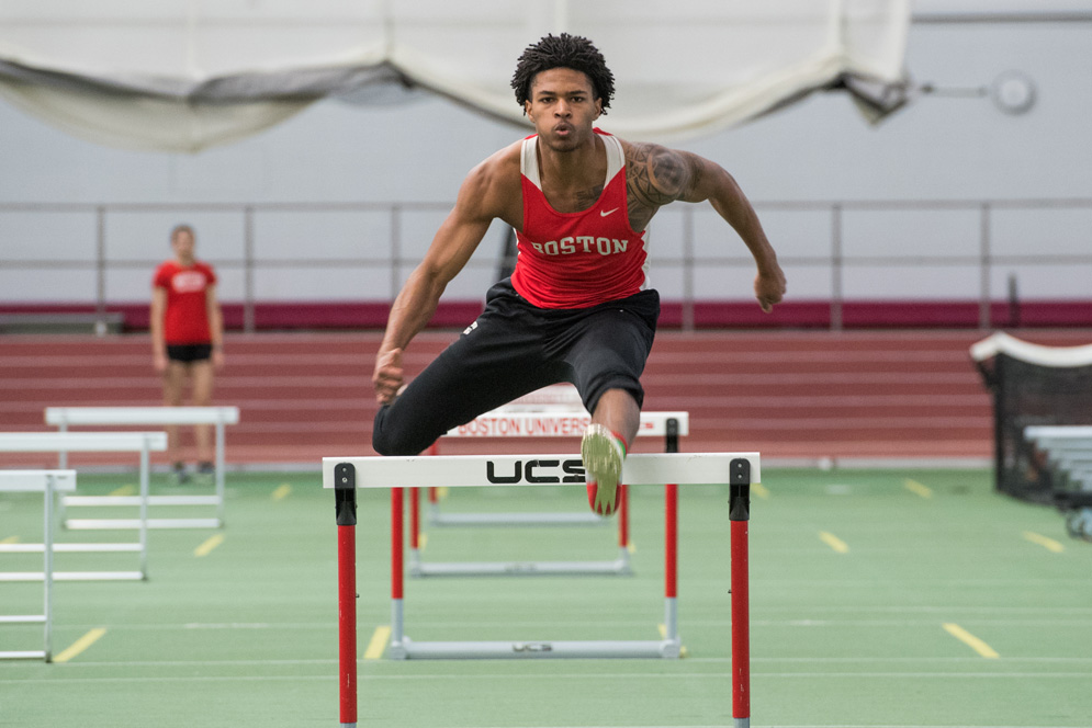 Jamie Harris leaps over a hurdle during track and field practice