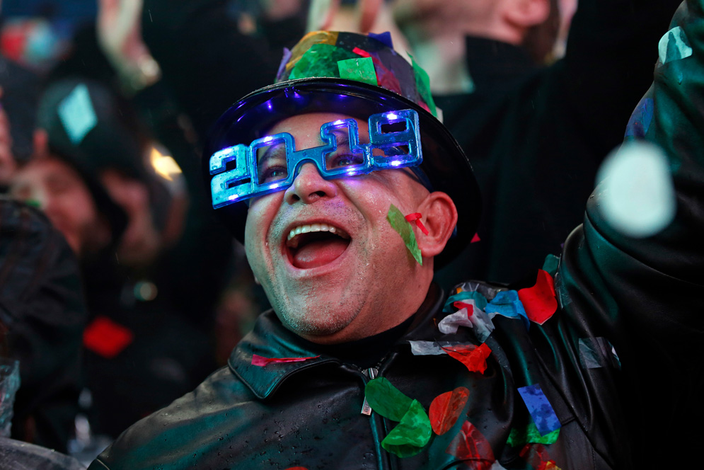 A person celebrates new years eve wearing 2019 glasses
