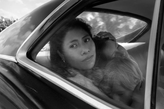 A mexican maid looks out the window of a car