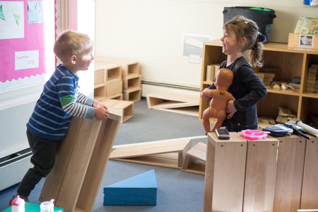 Two children play and laugh at the BU Children's Center 