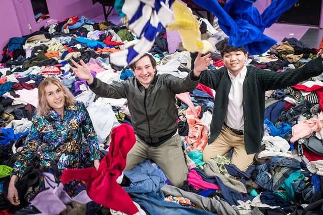 Students playfully toss cloths at the camera in the garment district