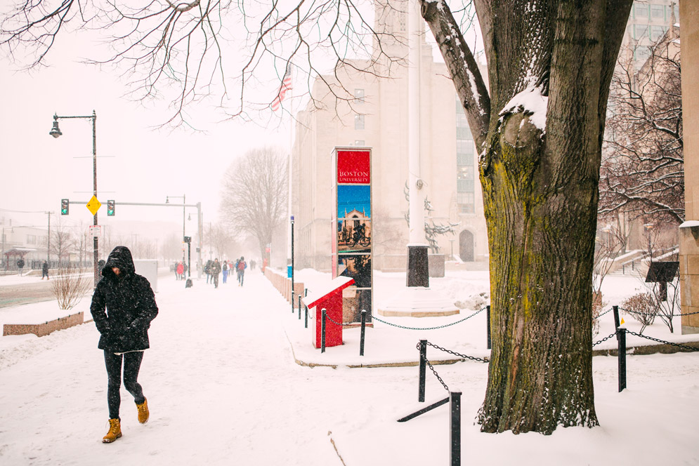 A student walks down Com Ave in front of Marsh Plaza