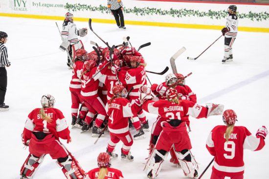 BU Women's hockey team celebrates their beanpot victory in a group embrace on the ice