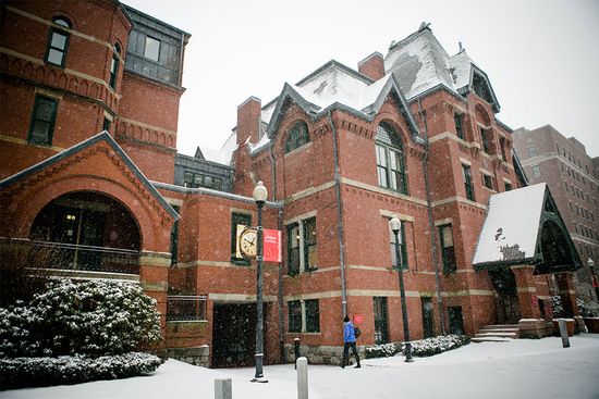 A person walks into a Boston University School of Medicine building in the snow.