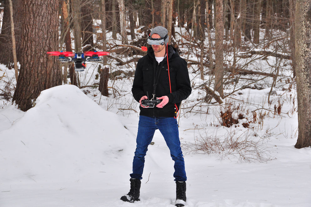 First-person-view droning is a technique where a person wears a headset connected to a video feed streaming live from a camera on the drone. Wil Koch, pictured here, uses the technique to operate a drone outfitted with a Neuroflight controller, which uses a trained neural network to maneuver through dynamic environmental conditions like wind. Courtesy of Wil Koch