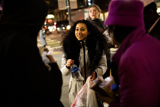 Junior Noha Yehia (ENG) offers water to homeless people on Mass Ave during Swipes for Boston’s February food run.