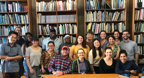 BU students posing in front of shelves full of books