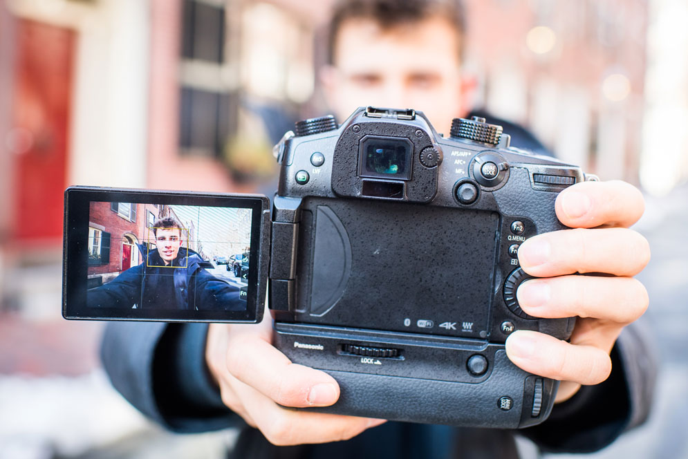 Arlin Moore holding a video camera with the screen showing himself