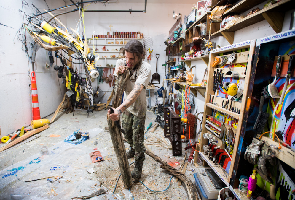 Painting major Max Bard (MFA'19) takes apart some wood he found to add to his work in his studio at 808 Commonwealth Ave.