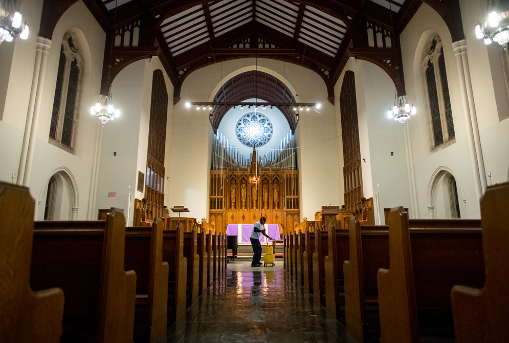 Custodian Augustine Asante at work on one of his nightly tasks, mopping the Marsh Chapel sanctuary floor. 