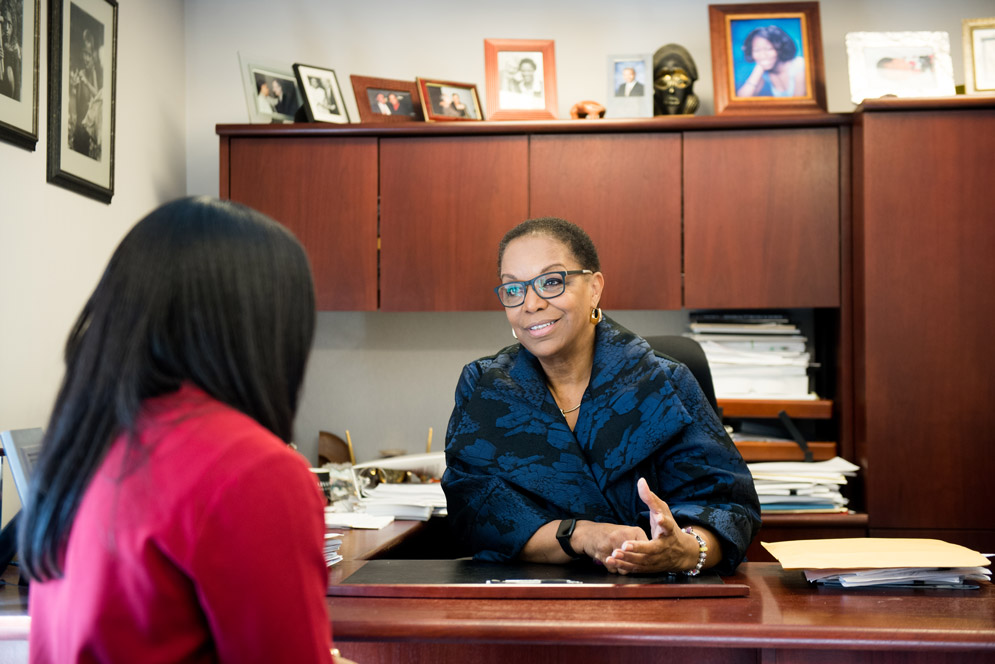 Reede speaks with colleagues in her office
