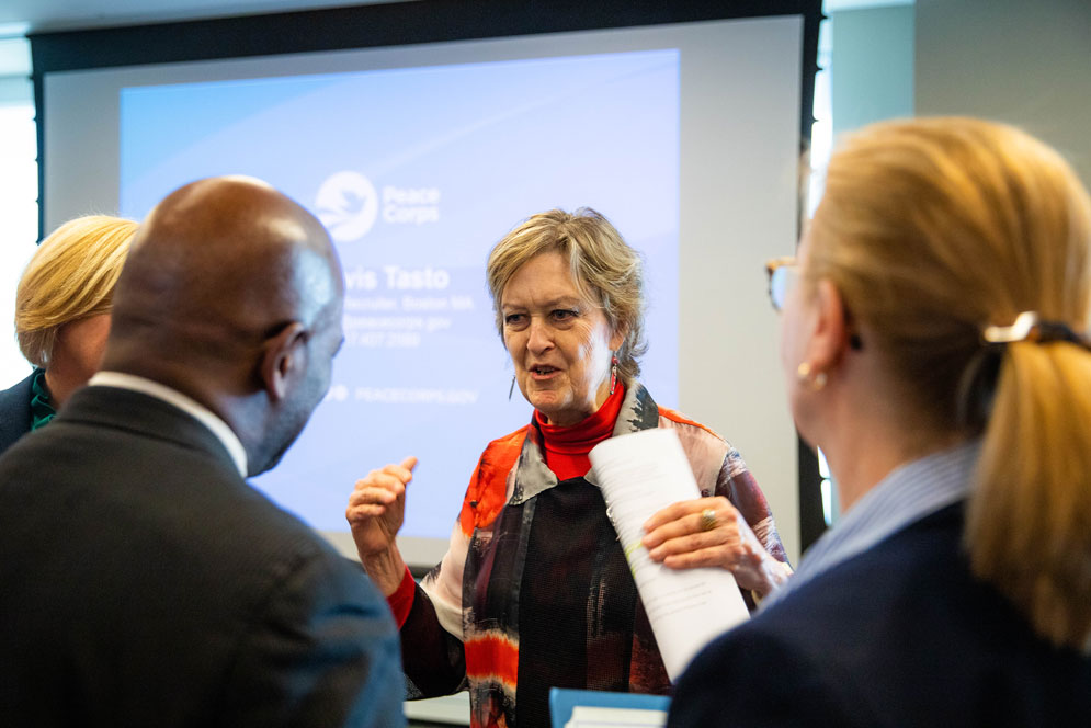 Jody Olsen conversing with a small group in front of a projector