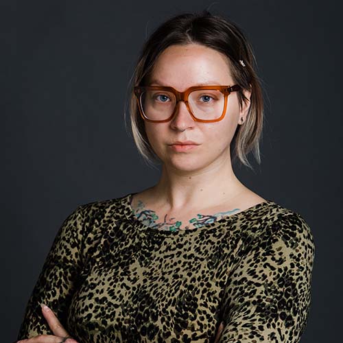 Photo of Janice Checchio, a white woman with short blonde hair and reddish glasses who wears a leopard print shirt.