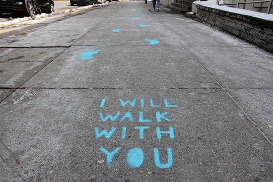 the sidewalk, with I WILL WALK WITH YOU and footprints painted on it in blue