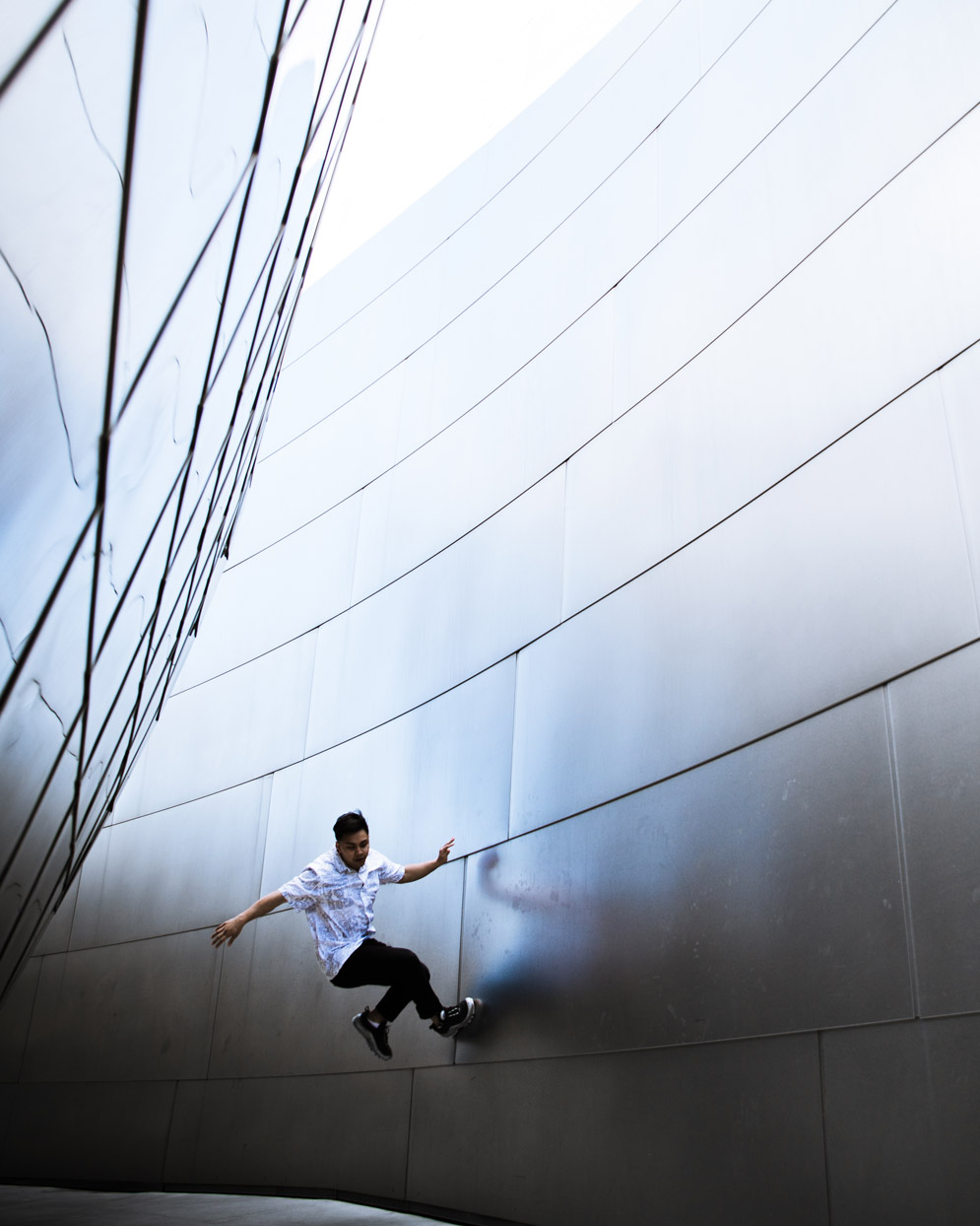 a person wall jumps on a silver tiled wall