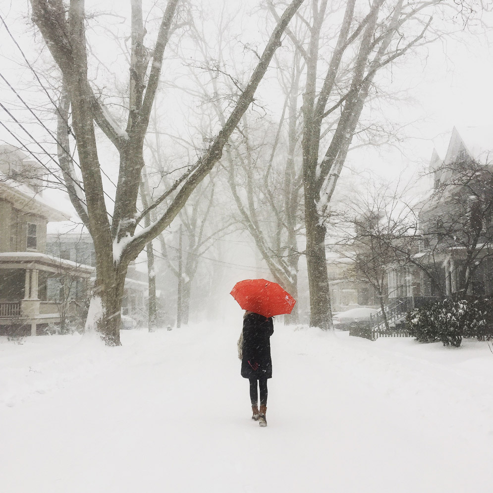 Grad student Jane Zitomer's (COM) entry - a person carrying a red umbrella in a white snowstorm