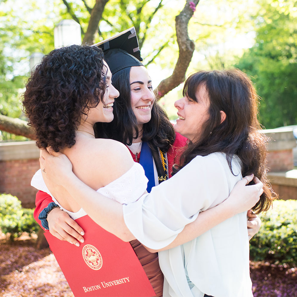 BU Class of 2019 graduate Jess Silva hugs her mother and sister after Commencement.