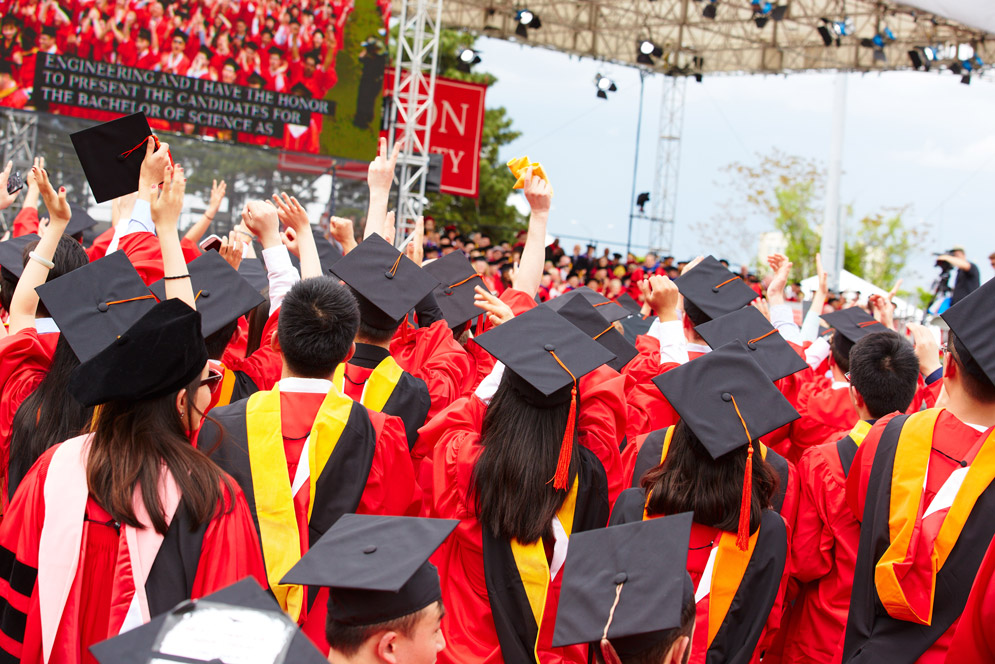 Graduates on Nickerson Field in caps, gowns and other regalia