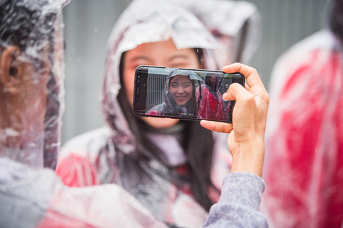 Students snap a selfie in the rain