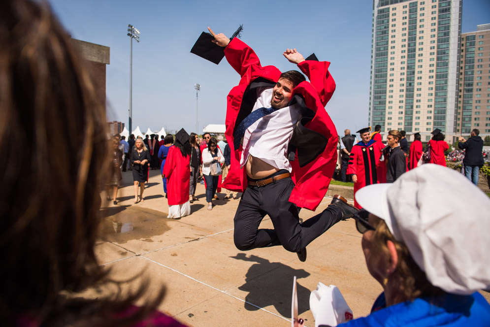 A graduate leaps in the air
