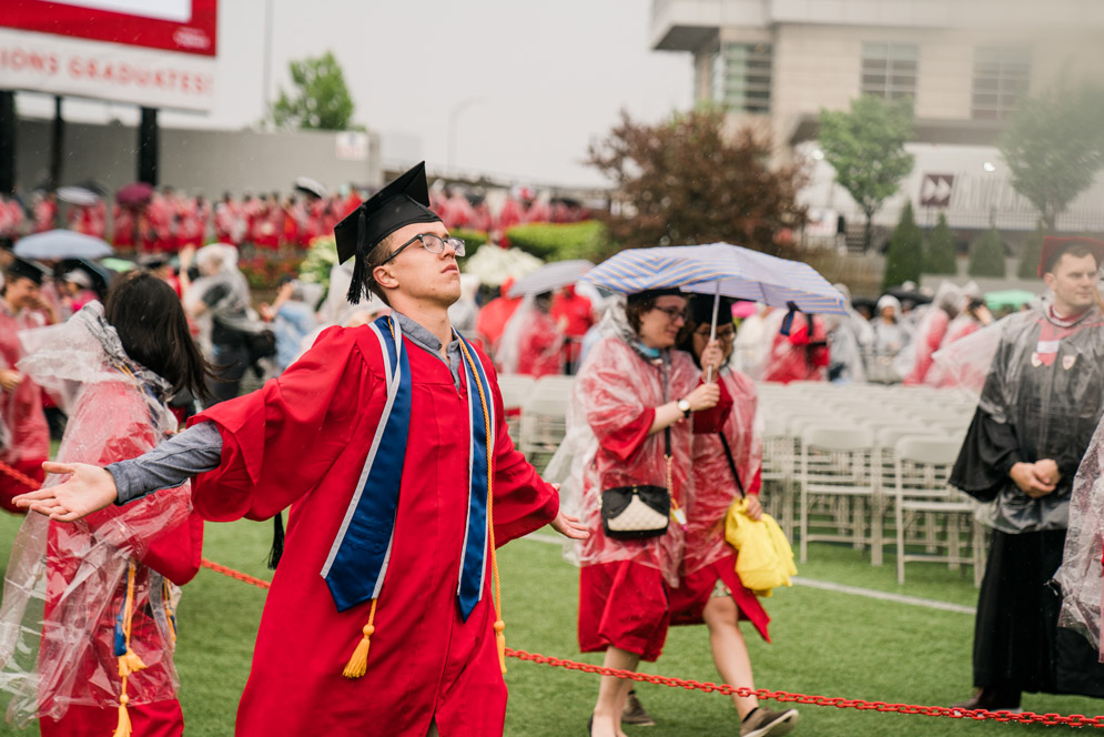 Graduates file onto Nickerson field in rain ponchos