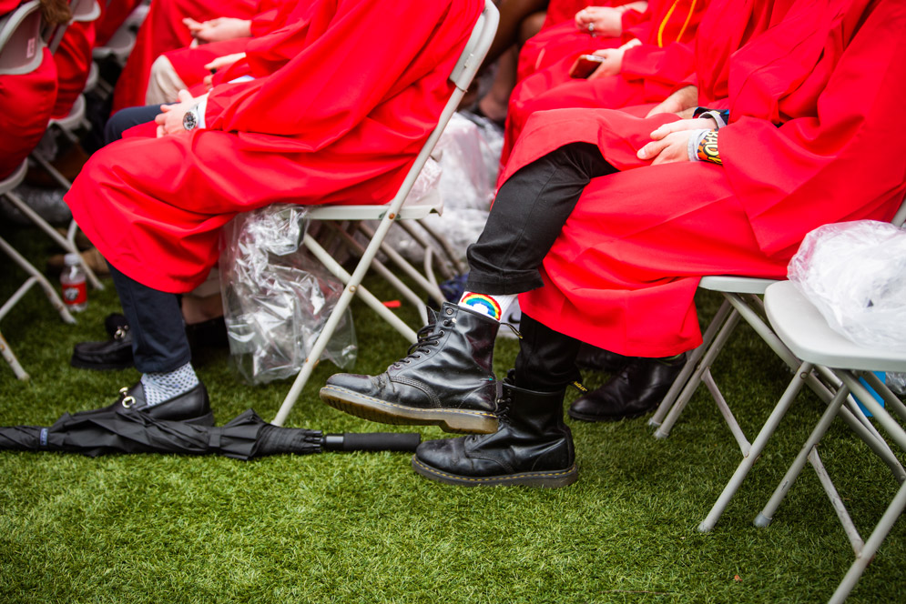 Rainbow socks peek out from beneath a red gown
