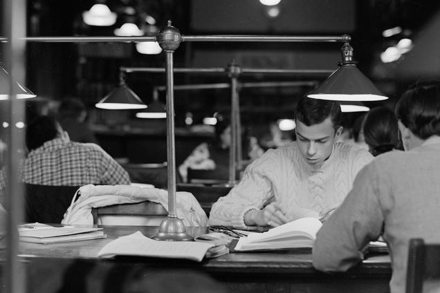 black and white photo of students studying in a library