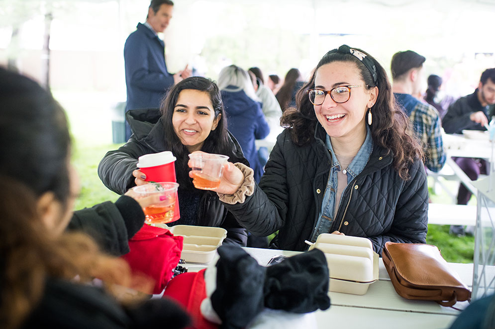 Boston University students toast drinks at an outdoor event