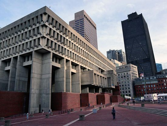View of Boston City Hall and plaza with skyline in the background.