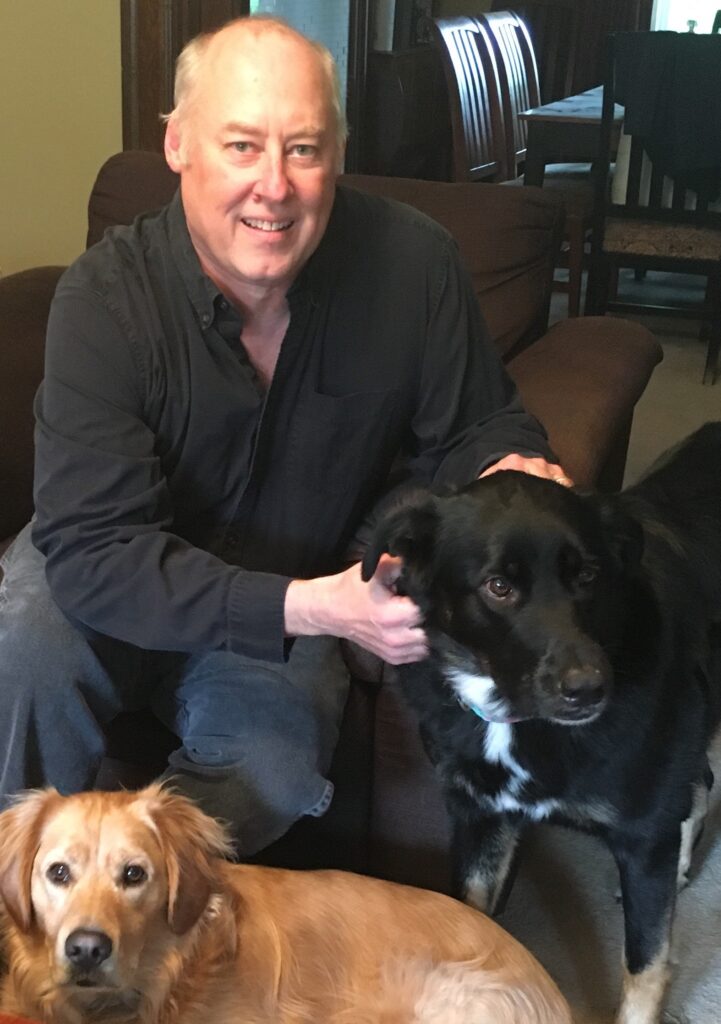 Stewart O'Nan sits in his home with his dogs
