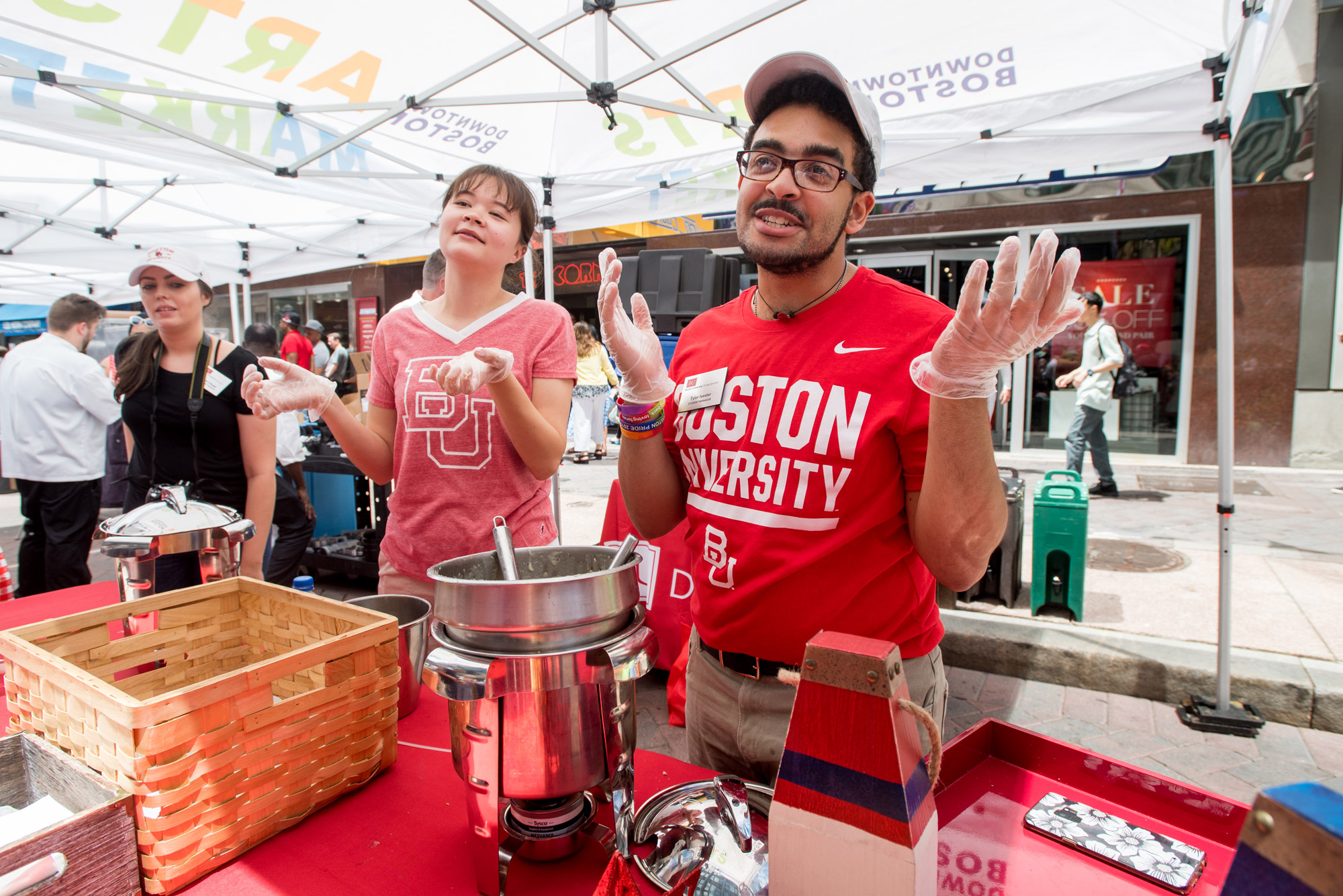 two students hand out samples of BU Dining Service's clam chowder at Boston Harbor Fest