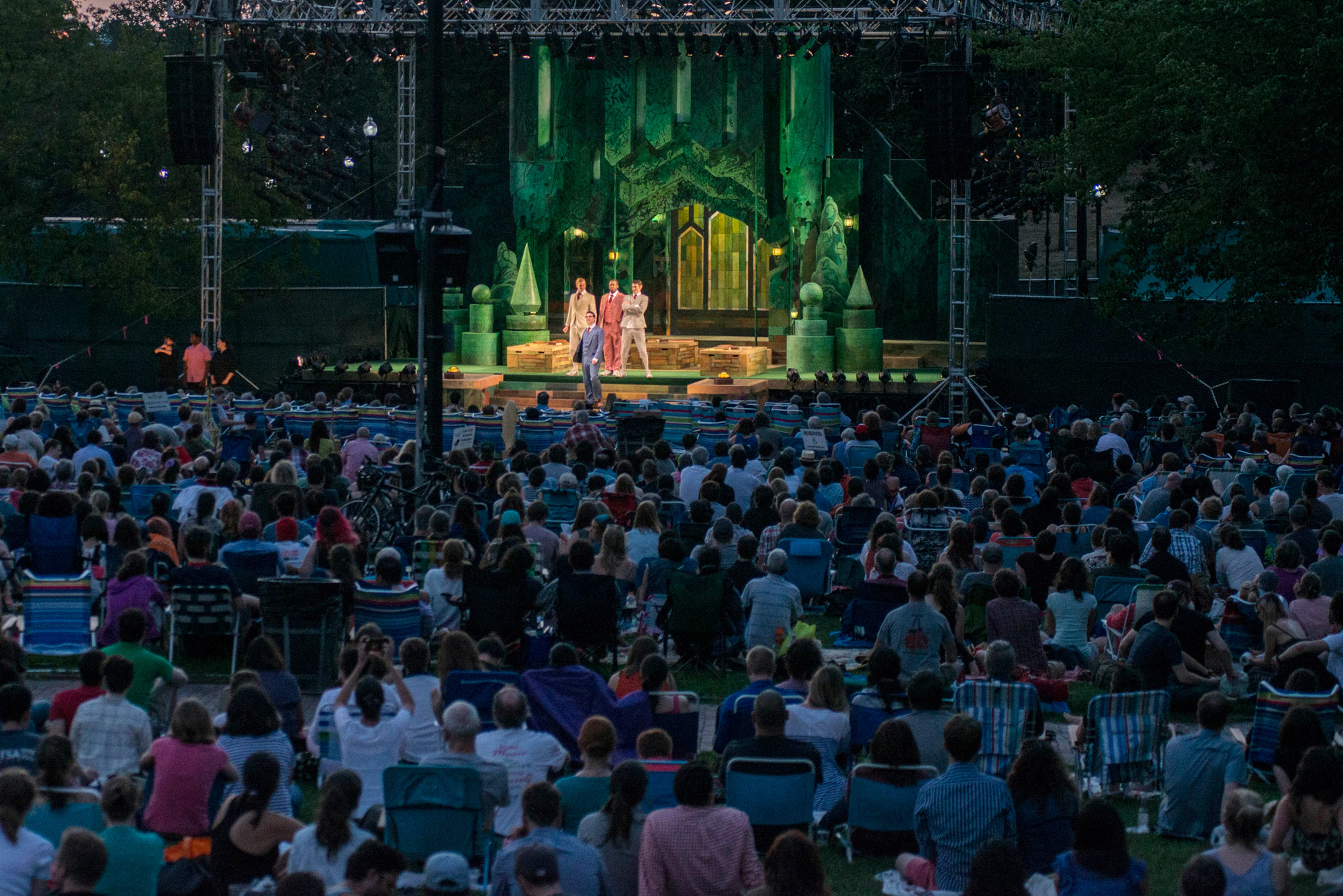 a crowd watches the Last year Commonwealth Shakespeare Company perform onstage