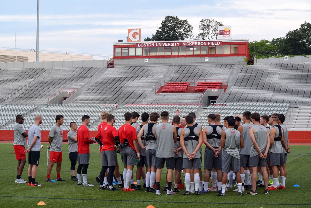 The Boston University men’s soccer team gathers on the field during a preseason practice.