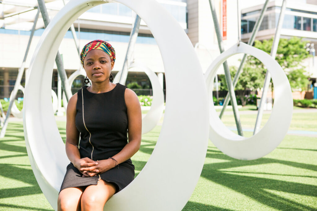 Portrait of Elaine Nsoesie sitting in a field of circular white swings.