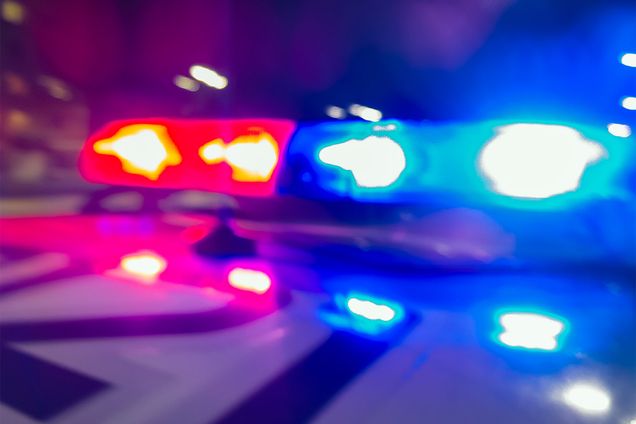 Detail photo of red and blue police car lights lit up at night.