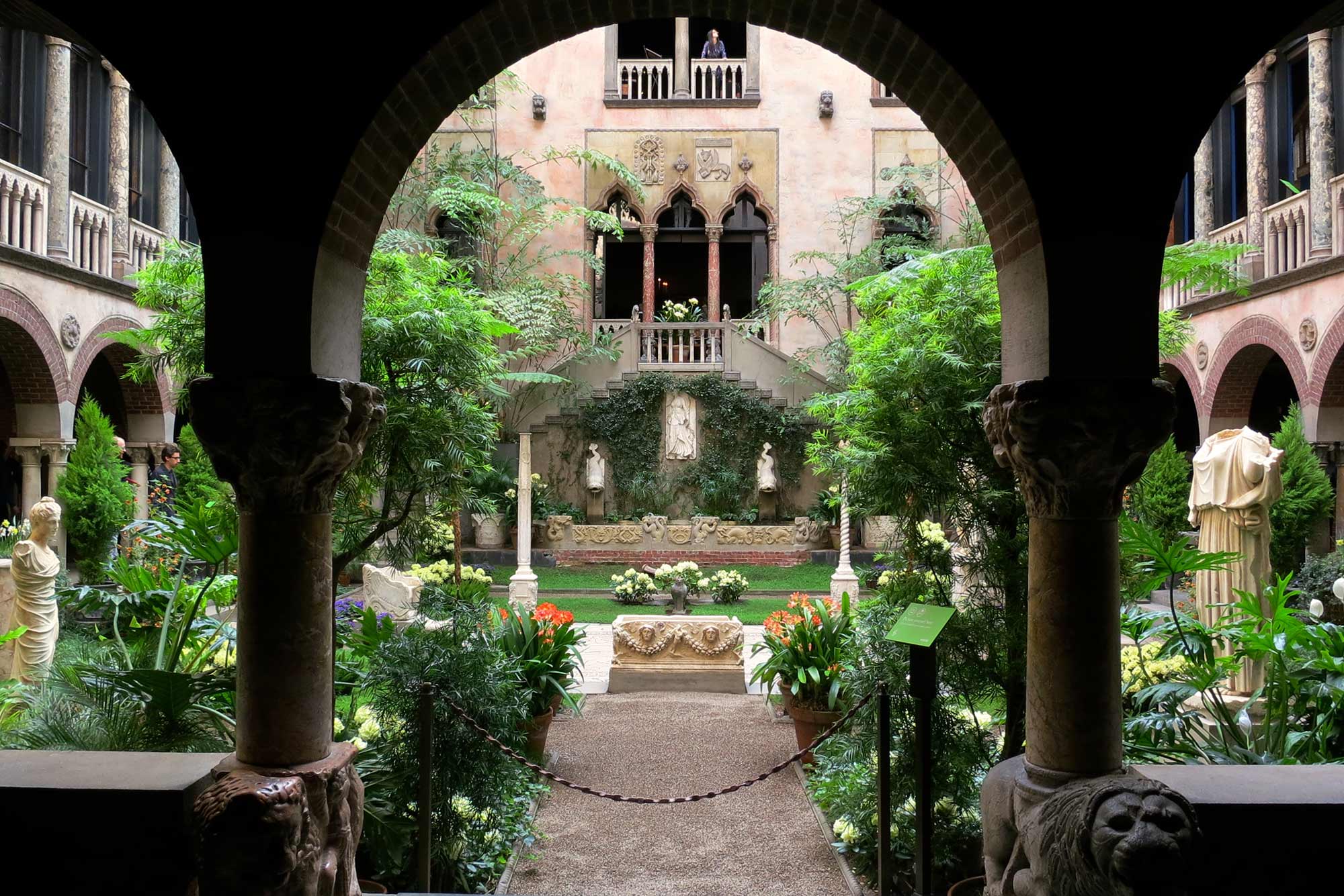 Photo of the courtyard at The Isabella Stewart Gardner Museum. The Venetian structure’s central garden is filled with greenery and flowers.