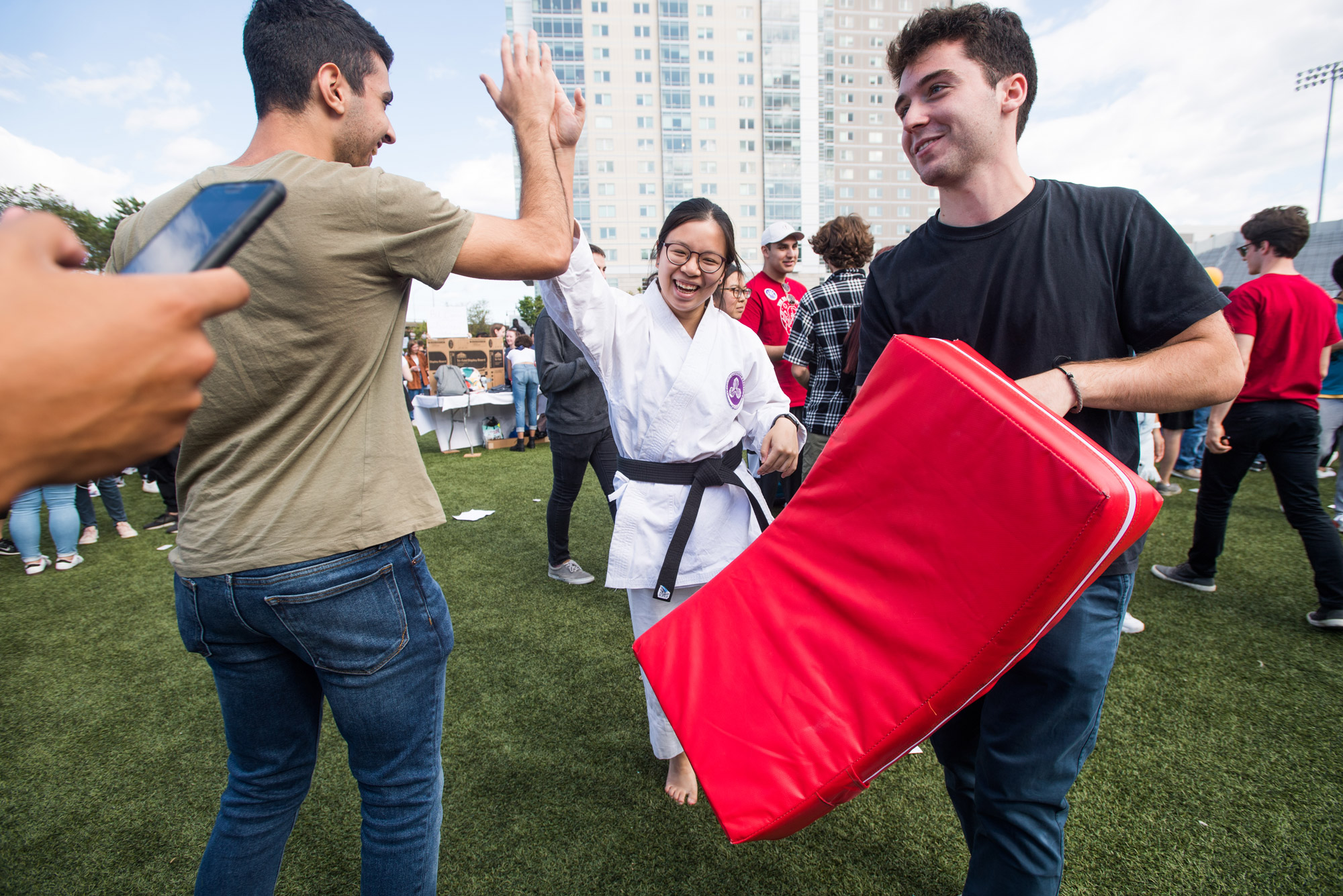 Shotokan Karate practitioner Lorraine Sim (CAS'18) high fives Daniel Delijani (CAS'23) on Nickerson field during Splash