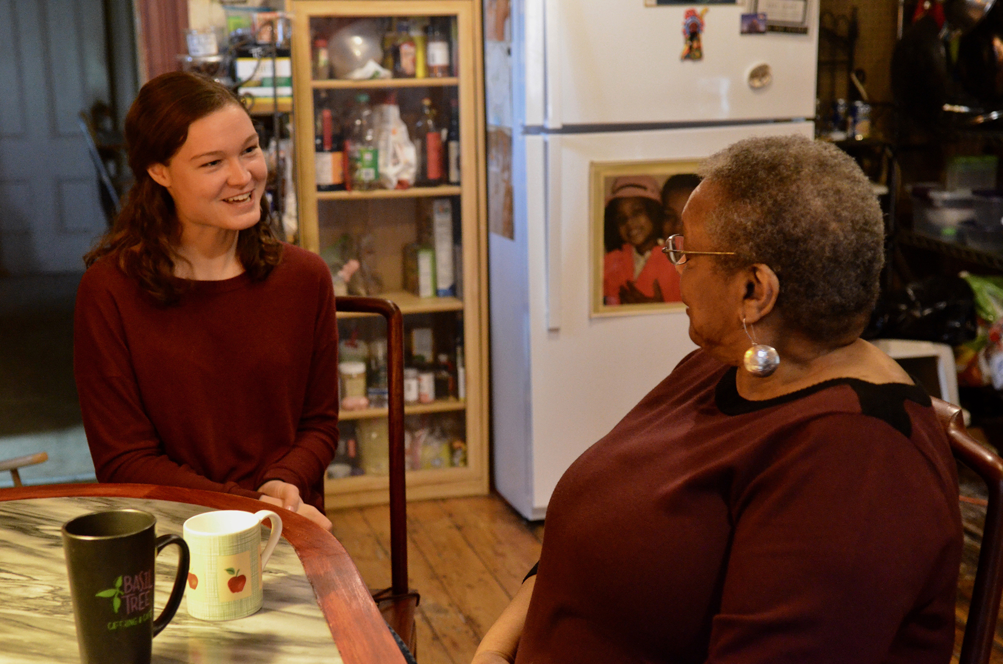 Abigail Herbst and Brenda Atchison talk over coffee in the kitchen.