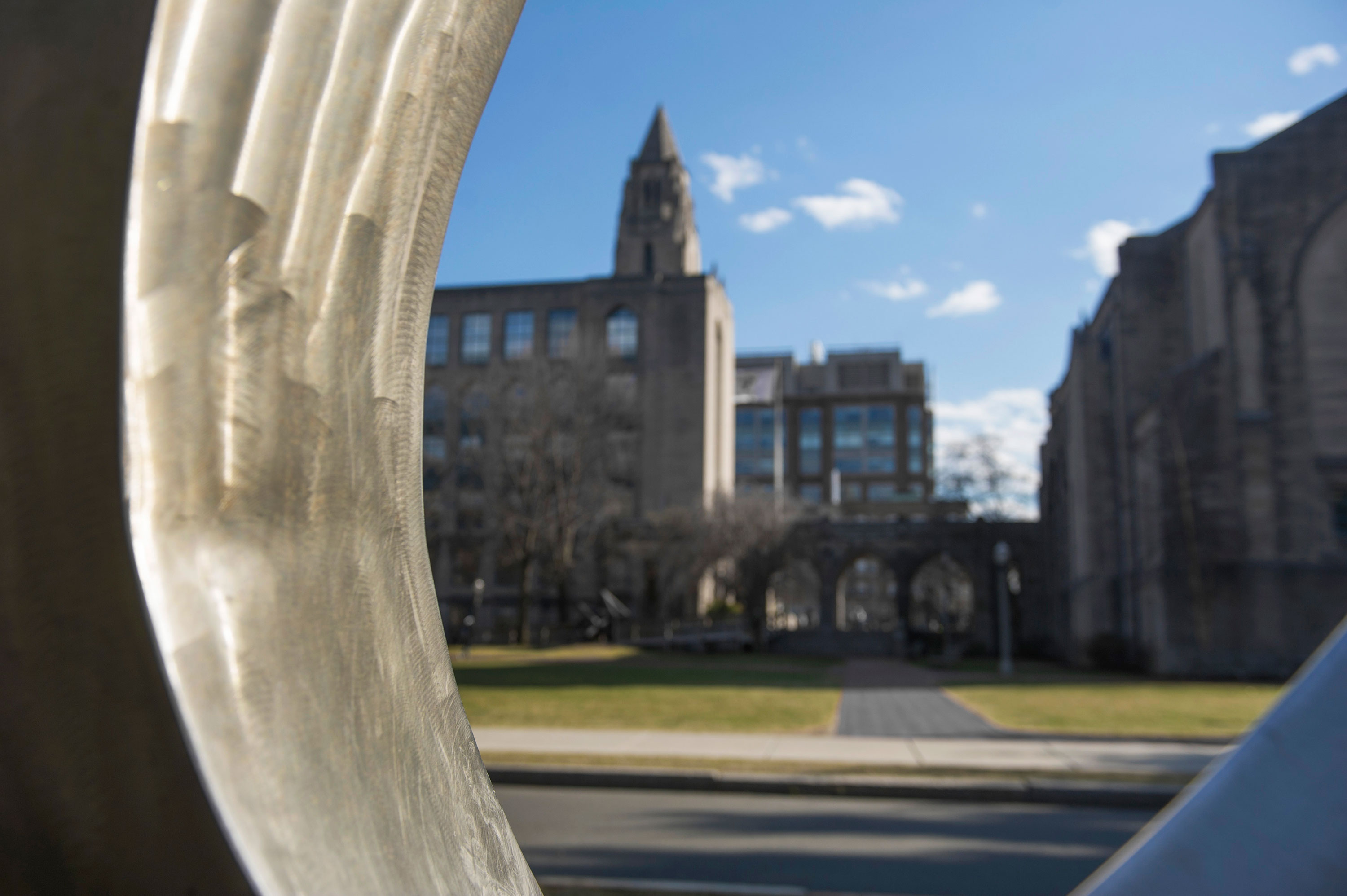 View of the Boston University College of Arts and Sciences building through the sculpture Counterpoint by Russell Jacques located on BU Beach.