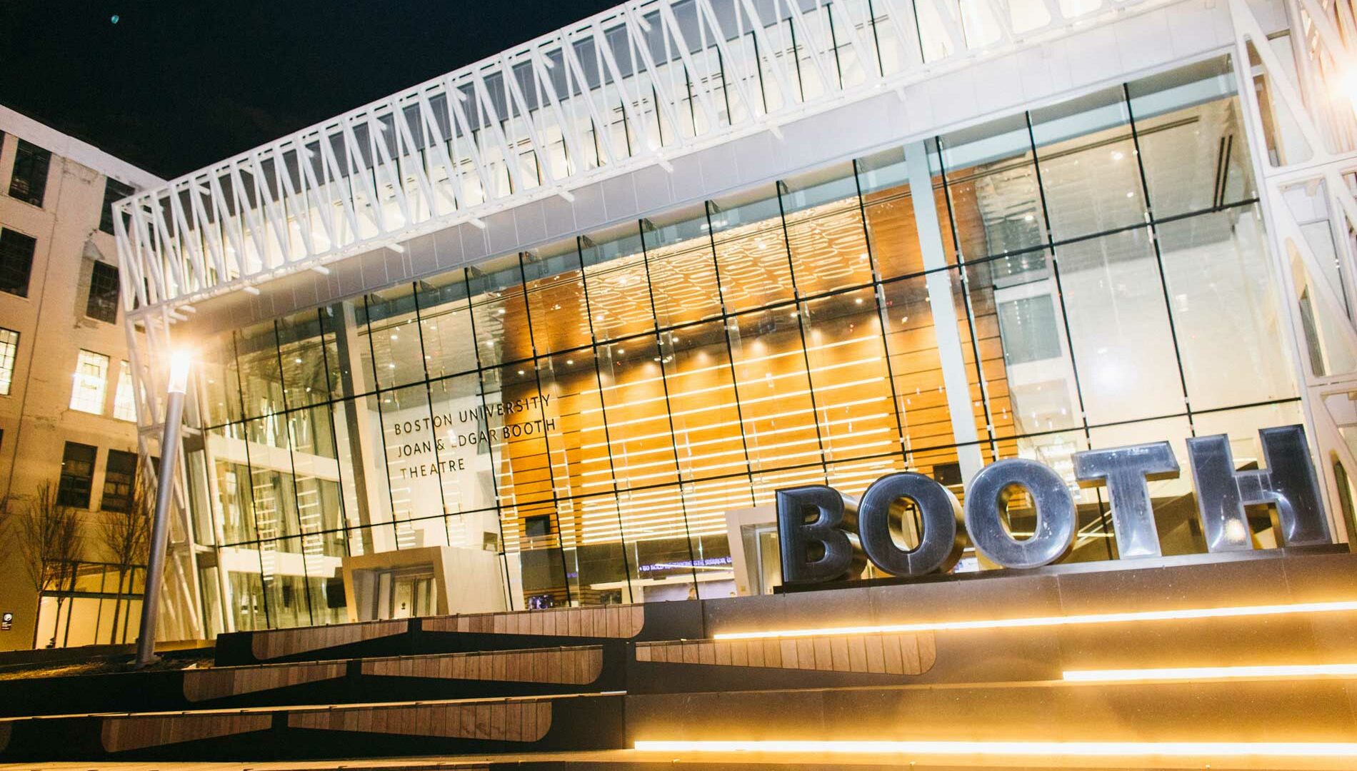 Exterior view of Boston University's Joan & Edgar Booth Theatre at night.