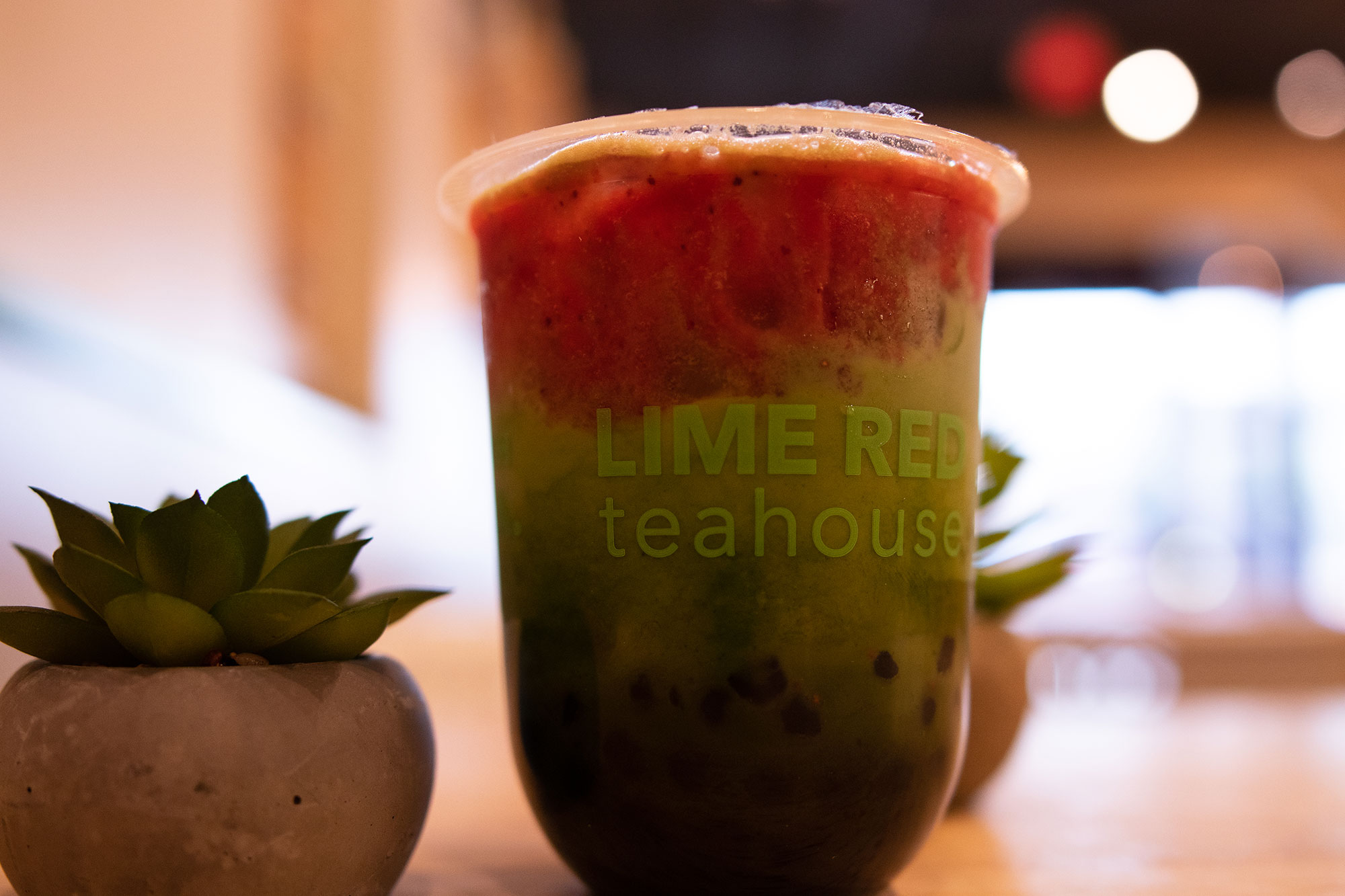 Product photo of a red and green drink made by LimeRed Teahouse in Allston, MA.