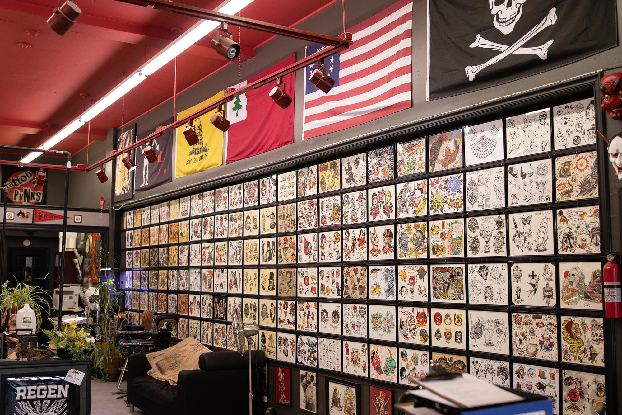 Interior view of Regeneration Tattoo shop in Allston, MA showing the various tattoo designs displayed on the wall.