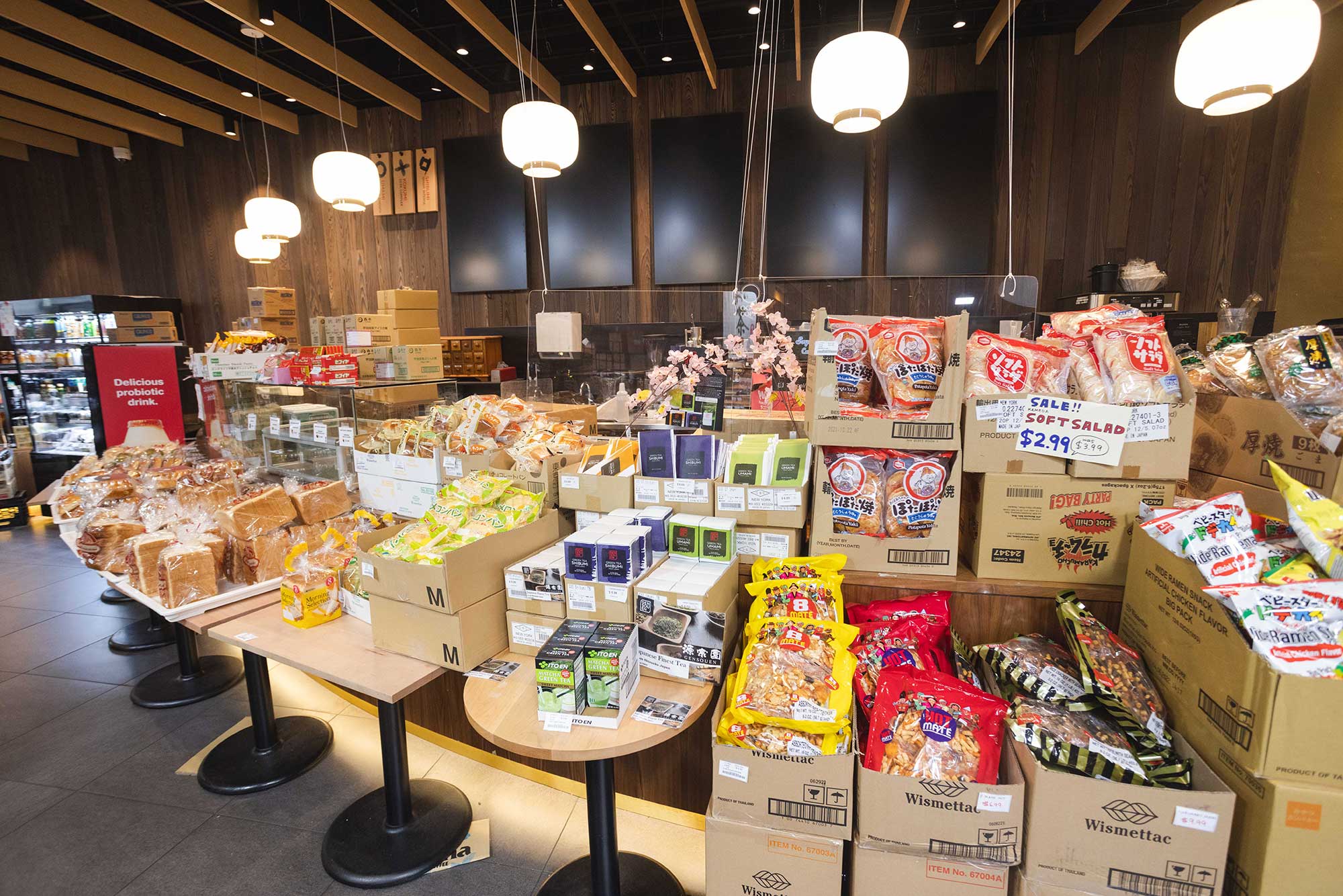 Photo of boxes filled with snacks on small tables inside Maruichi Japanese Food and Deli (299 Harvard St.).