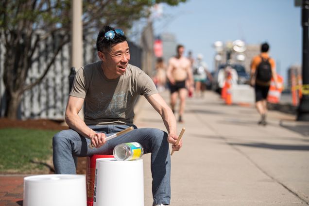 Kinh Vu drums on a plastic bucket on Comm Ave