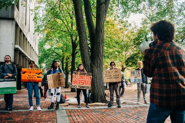 Students in a line hold signs protesting Ben Shapiro speaking on campus