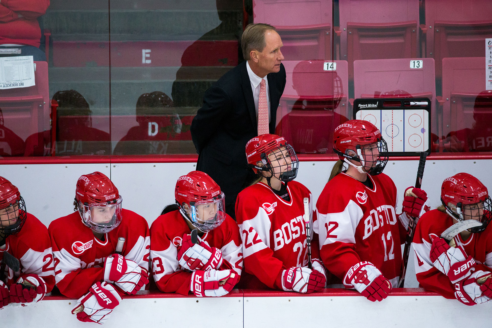 Boston University Terriers women's hockey coach Brian Durocher and players watch the game from the bench.