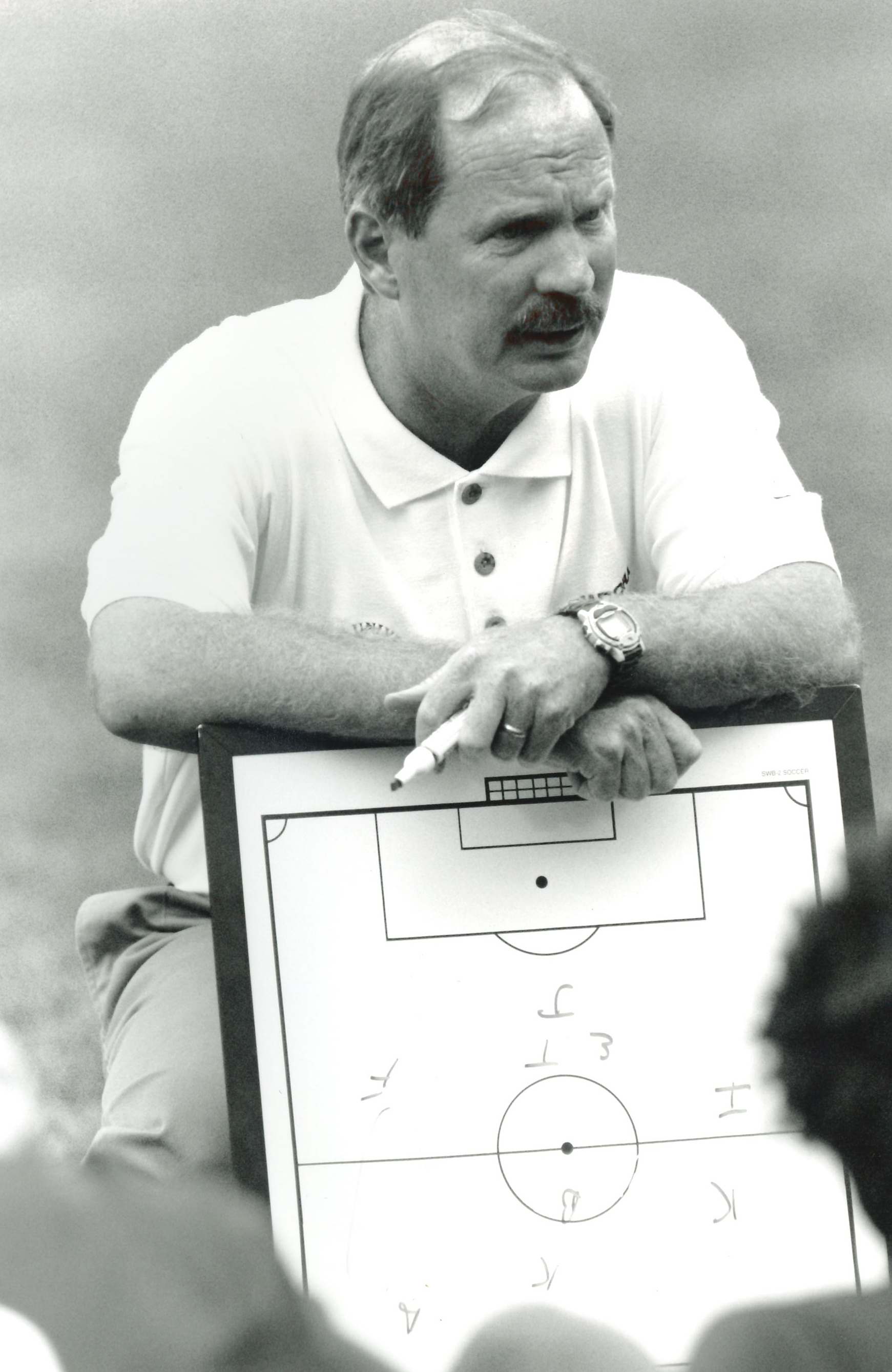 Neil Roberts holds a whiteboard while drawing out a play for his team